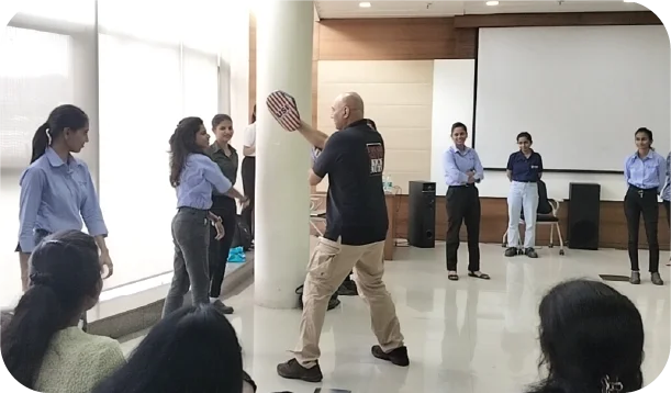 Instructor guiding participants through defensive movements in classroom session